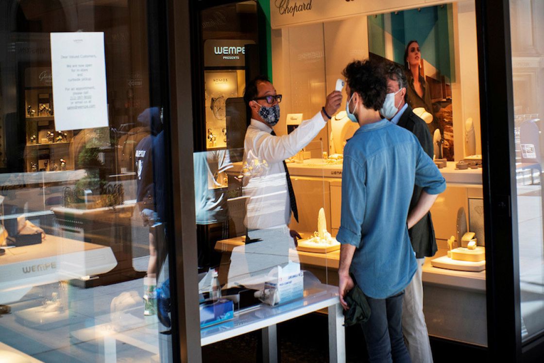 Un dependiente toma la temperatura a una persona en una tienda de la ciudad de Nueva York, Estados Unidos, el 12 de junio de 2020.